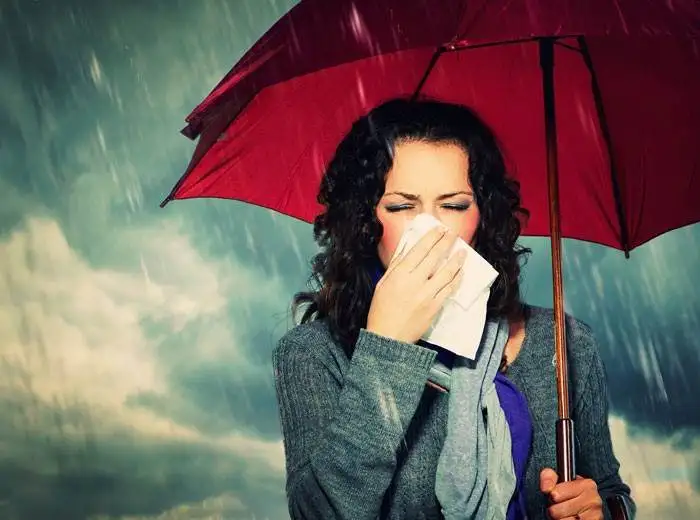 Sneezing Woman with Umbrella over Autumn Rain Background. Sick W